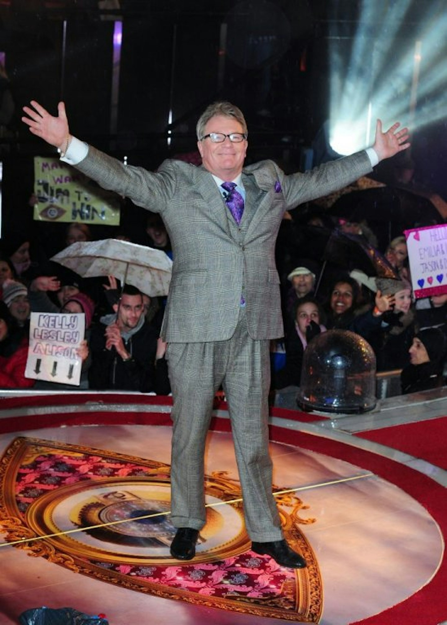 Jim Davison holding arms up with grey suit on