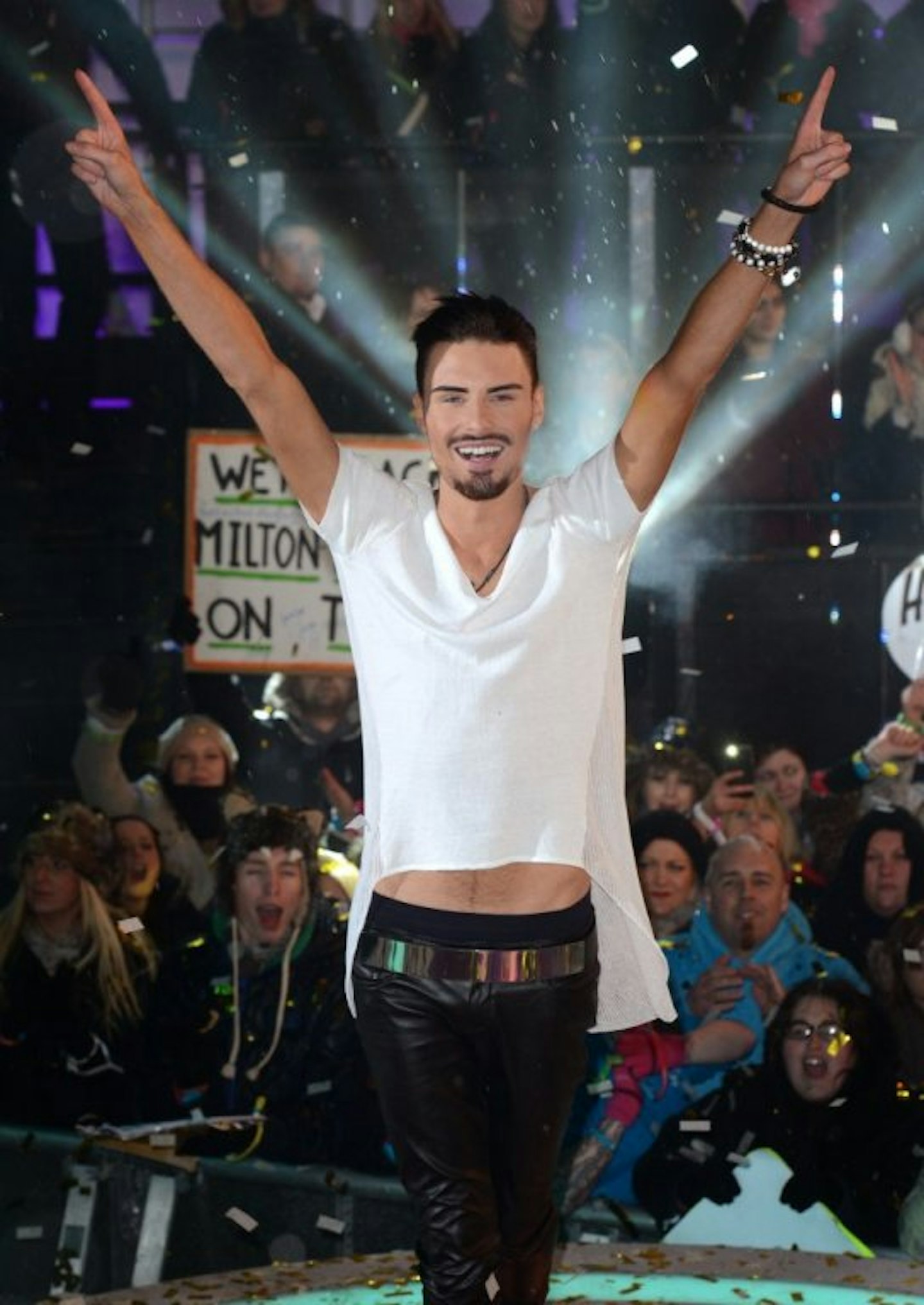Rylan holding arms up with a white t-shirt and black skinny jeans