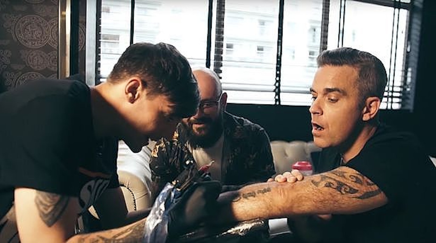 ROBBIE LOOKS PRETTY HAPPY WITH HIS NEW TAT 