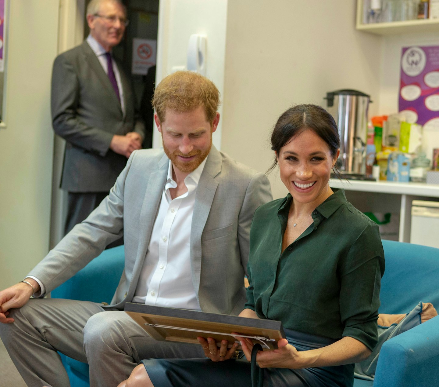 Prince Harry and Meghan Markle with a framed illustration of their dog, Guy. 