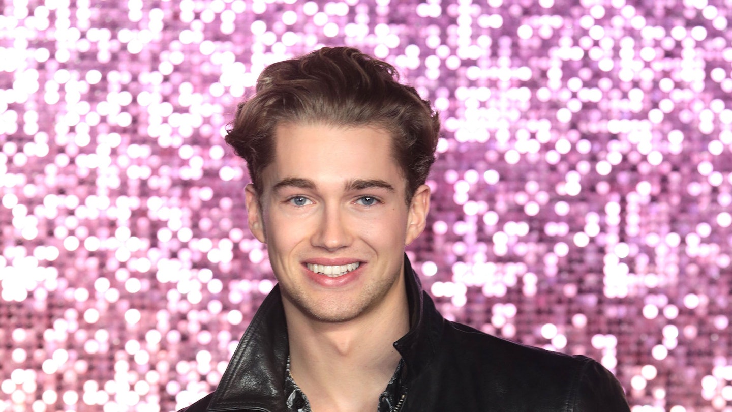 AJ Pritchard poses against a sparkly background