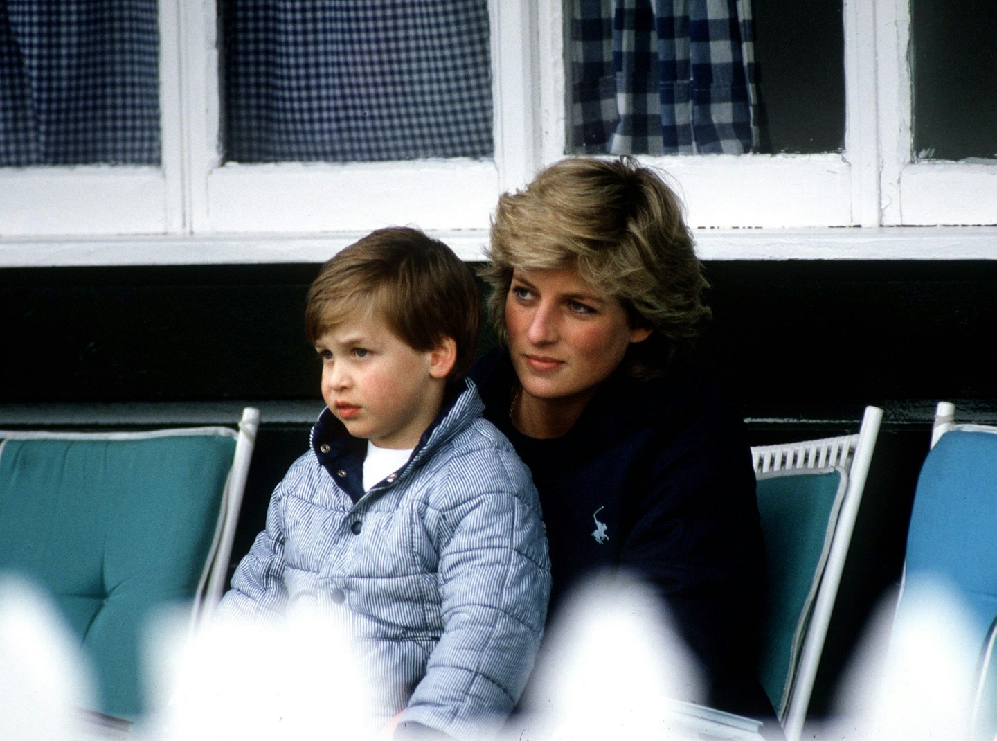Prince William sits on Princess Diana's knee at a polo match in 1987