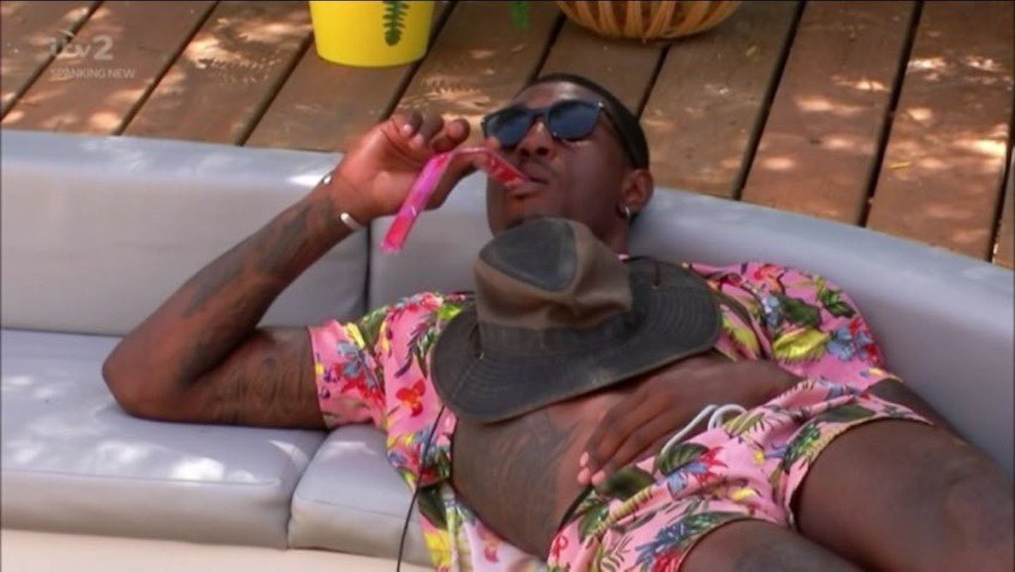 ovie from love island lounging on a chair.