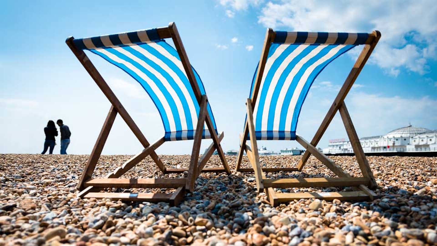Two deckchairs on a beach