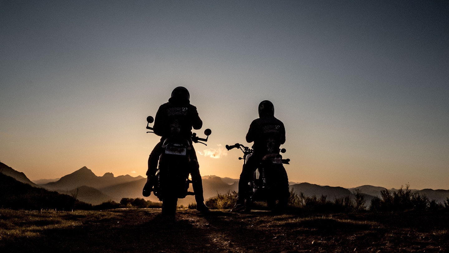Two bikers in the sunset using satnavs