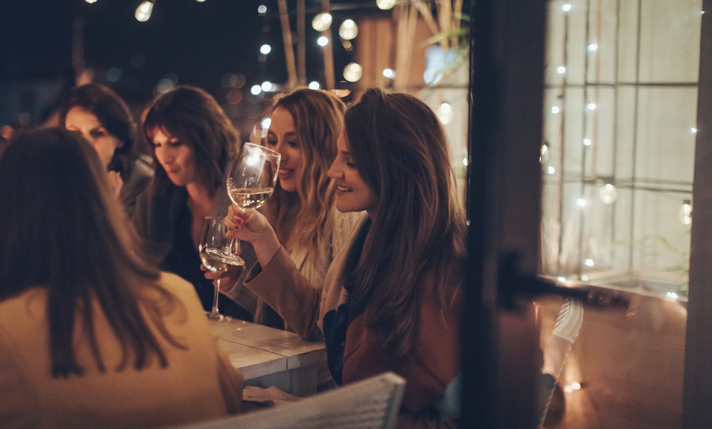 Women sat around table drinking wine