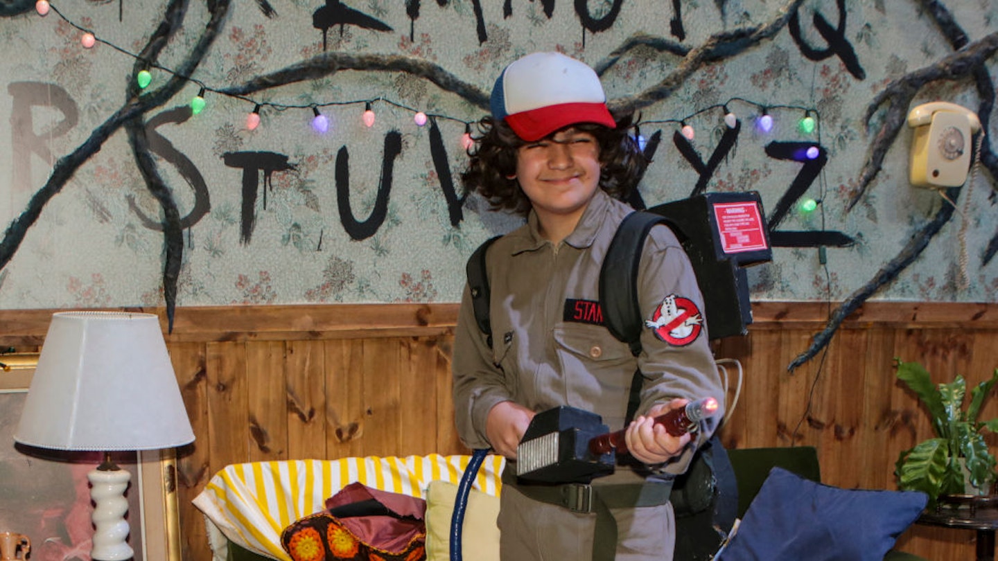 Young fan wearing a Stranger Things costume poses in the Netflix booth 