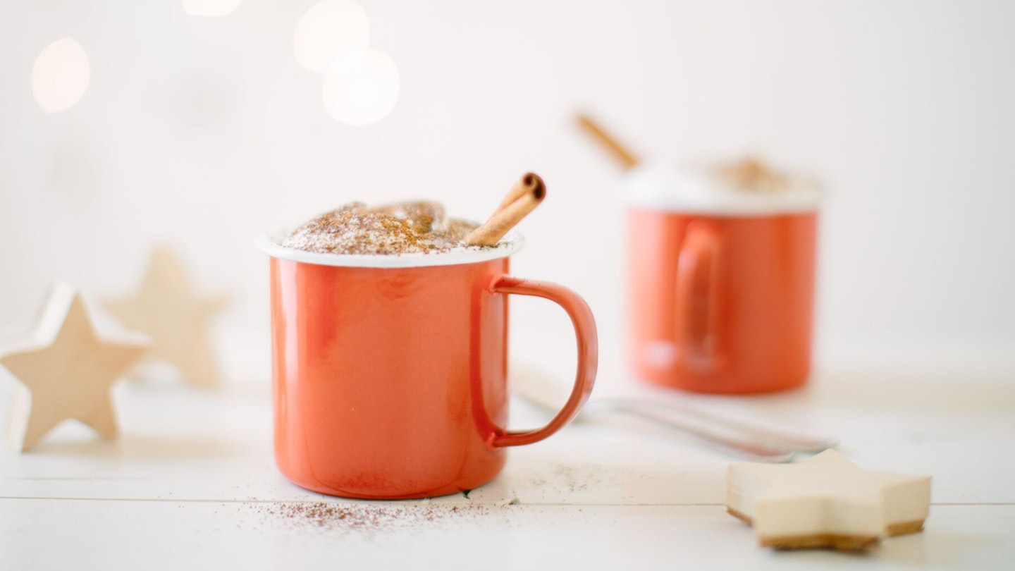 Hot chocolate in red mugs with cinnamon
