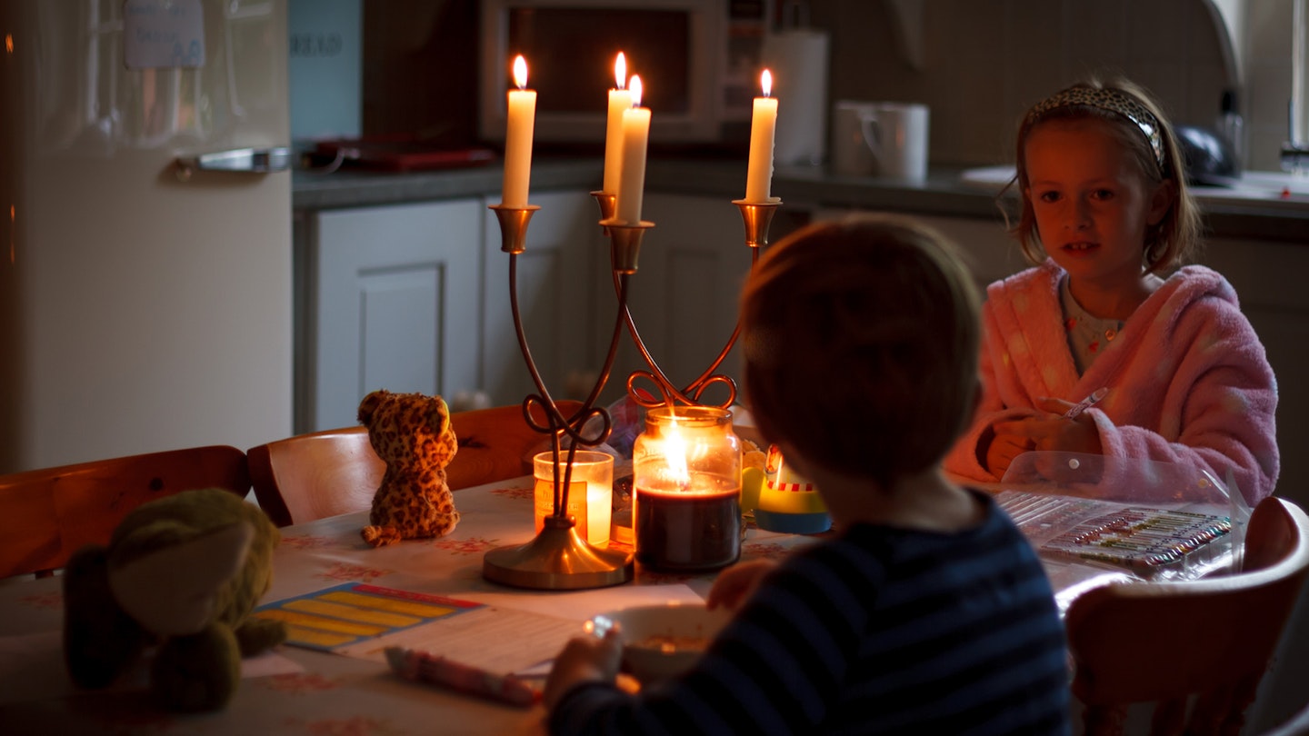 Children in the kitchen around candles