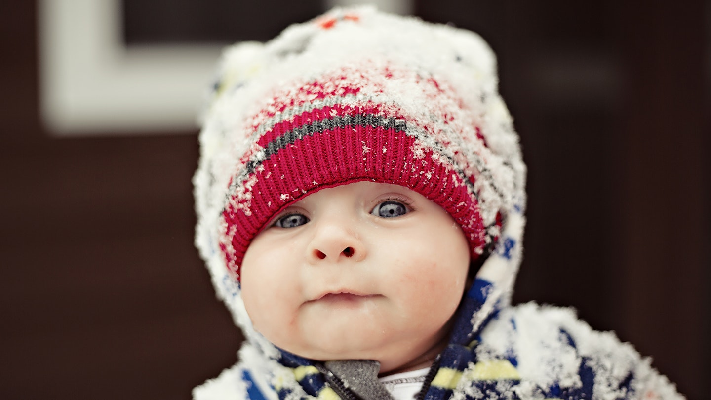 Baby in winter with snow on hat