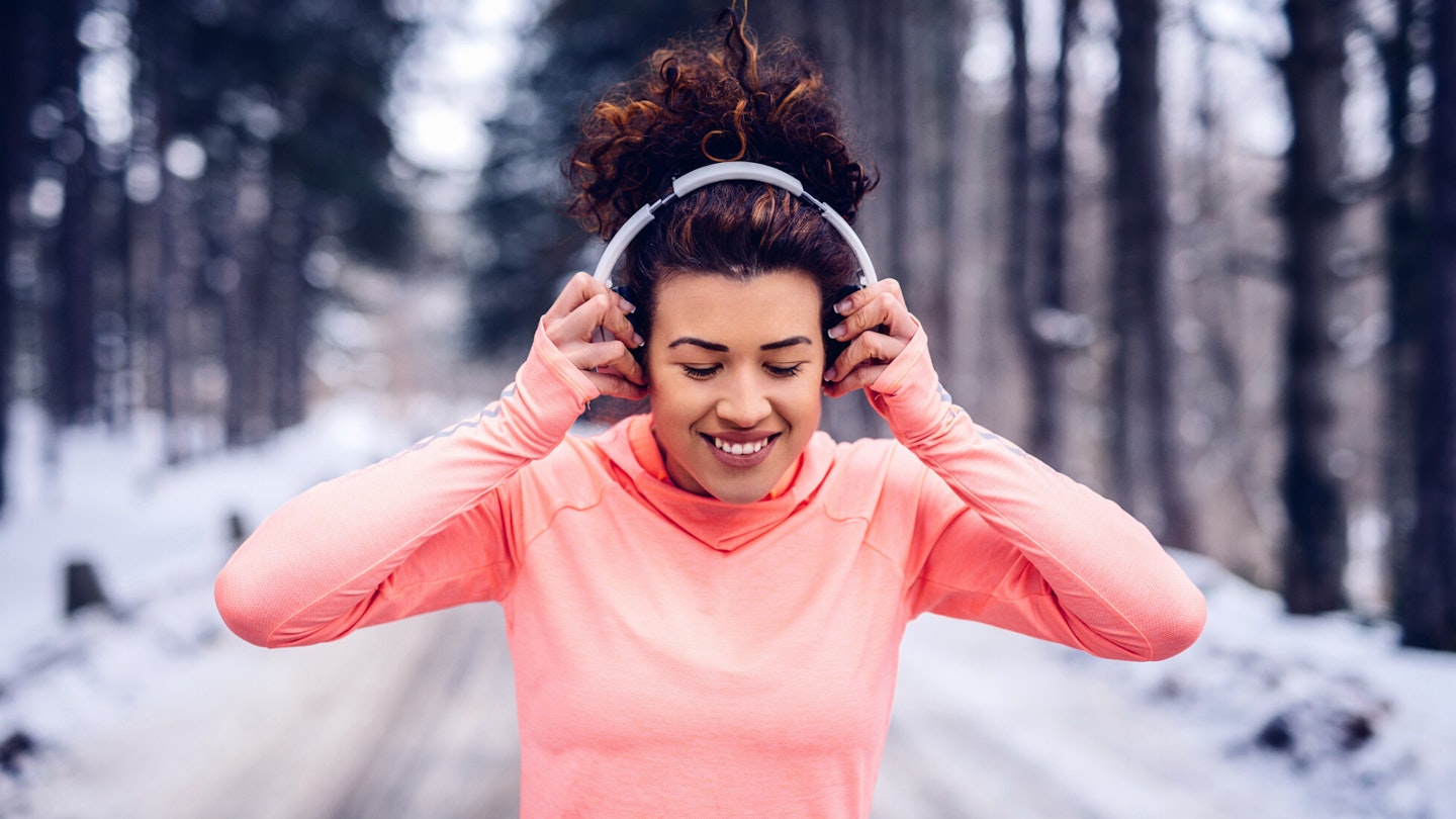 Woman running while wearing headphones