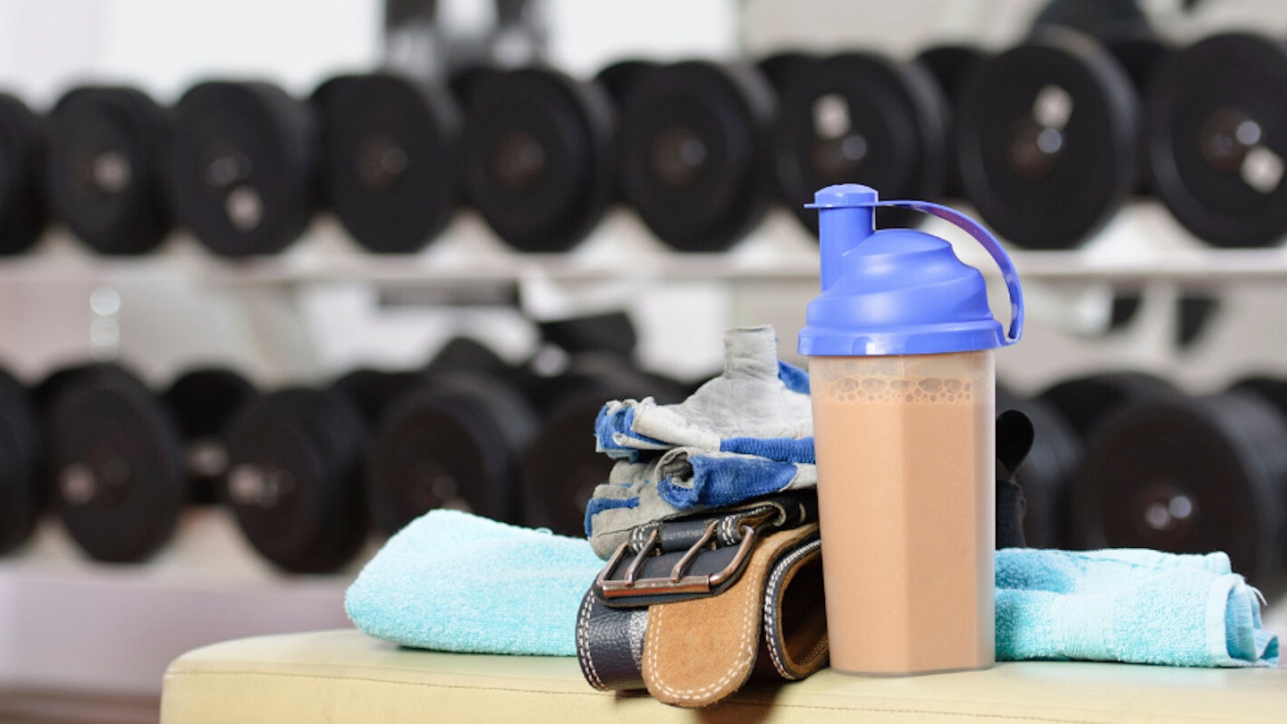 Protein shaker bottle on bench in gym