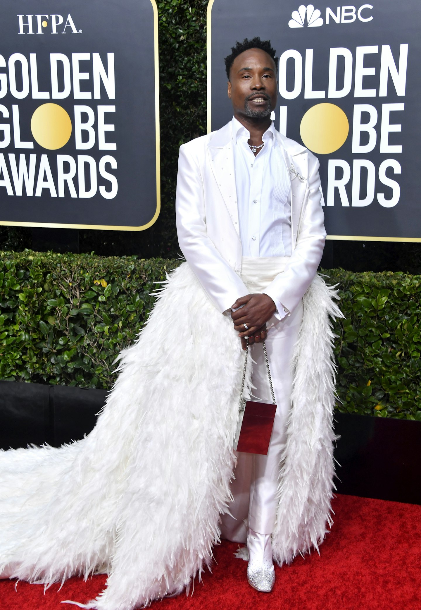 Billy Porter in a white suit with feather-trimmed jacket