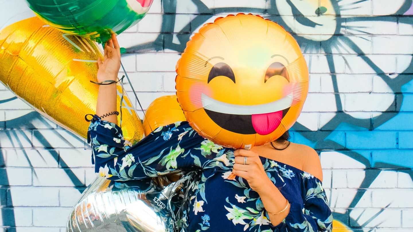 Woman with smiling emoji balloon