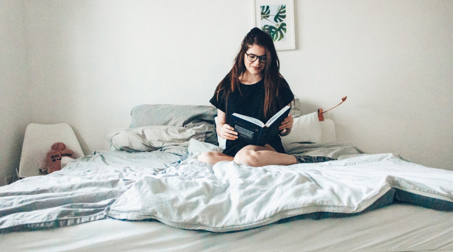 Woman on bed reading book