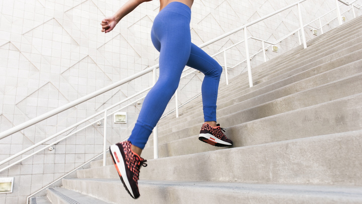 Woman in the best gym leggings running up steps