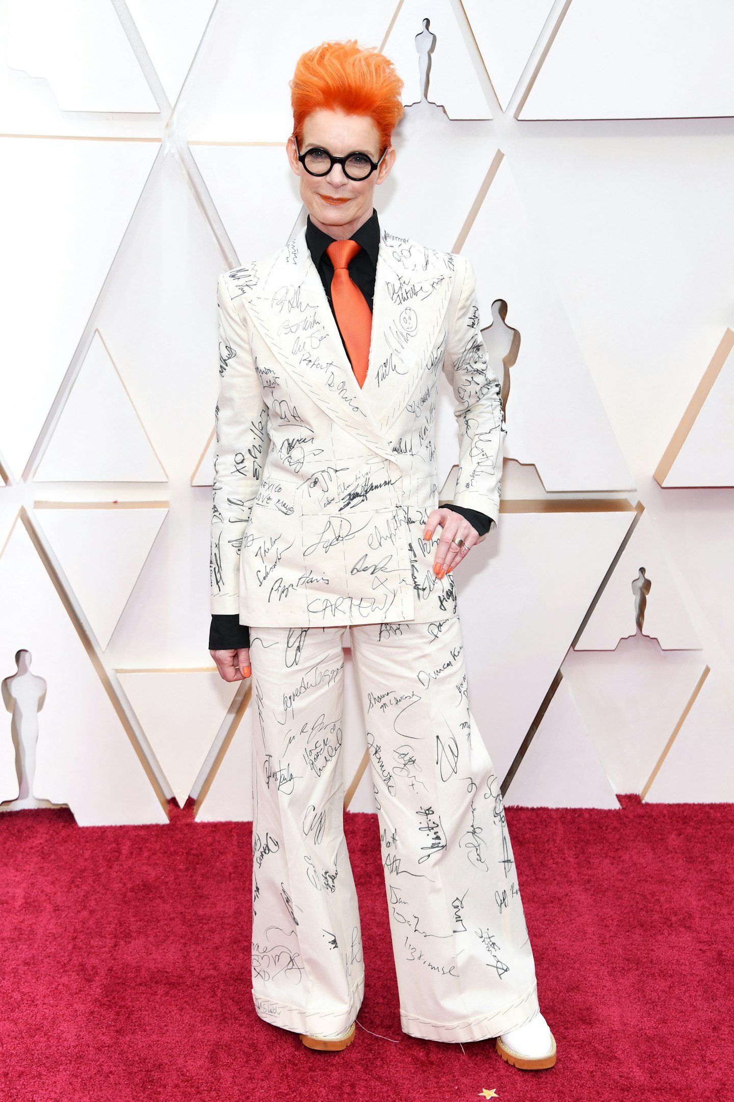 Costume designer Sandy Powell wore the same suit she wore to the BAFTAs, which was signed by an array of A-listers and will be auctioned for charity