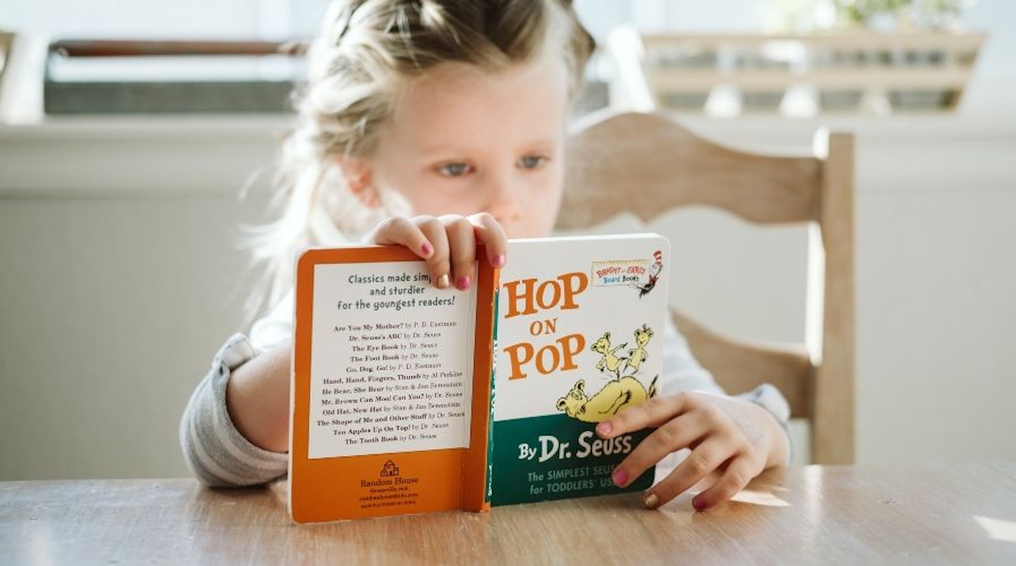 Girl reading Hop on Pop by Dr. Seuss