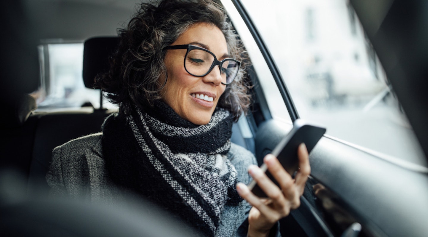 Woman using mobile internet while in a car