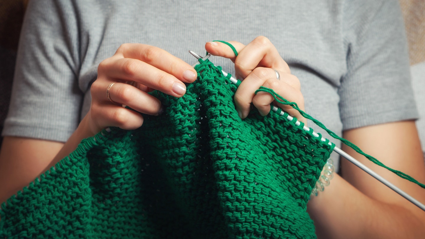Knitting needles and green wool 