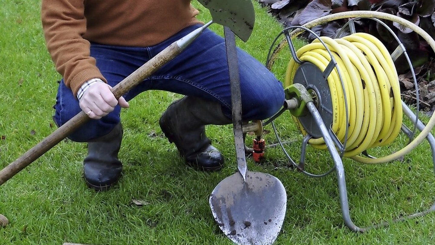 Gardener maintaining a lawn with tools