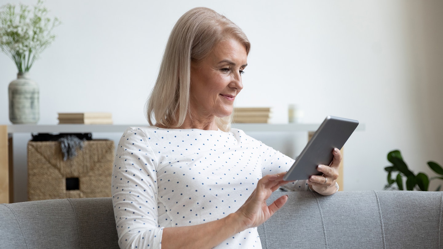 Woman using an e-reader to read a book