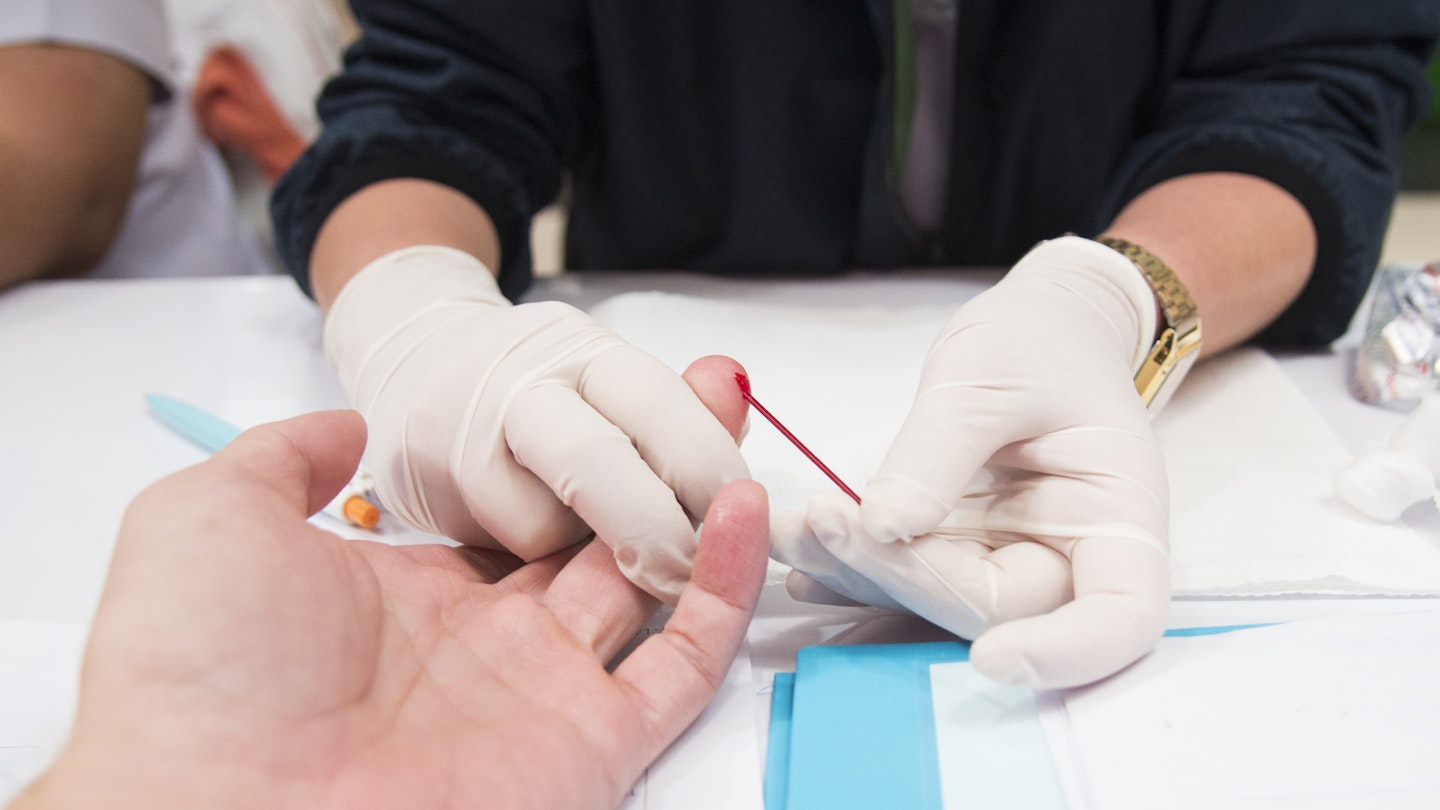 Woman getting finger prick blood test