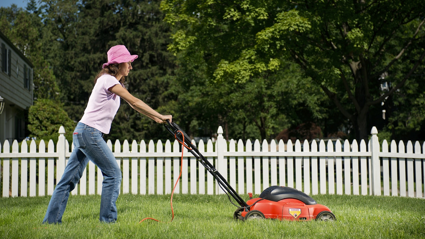 Woman mowing lawn with lawn mower