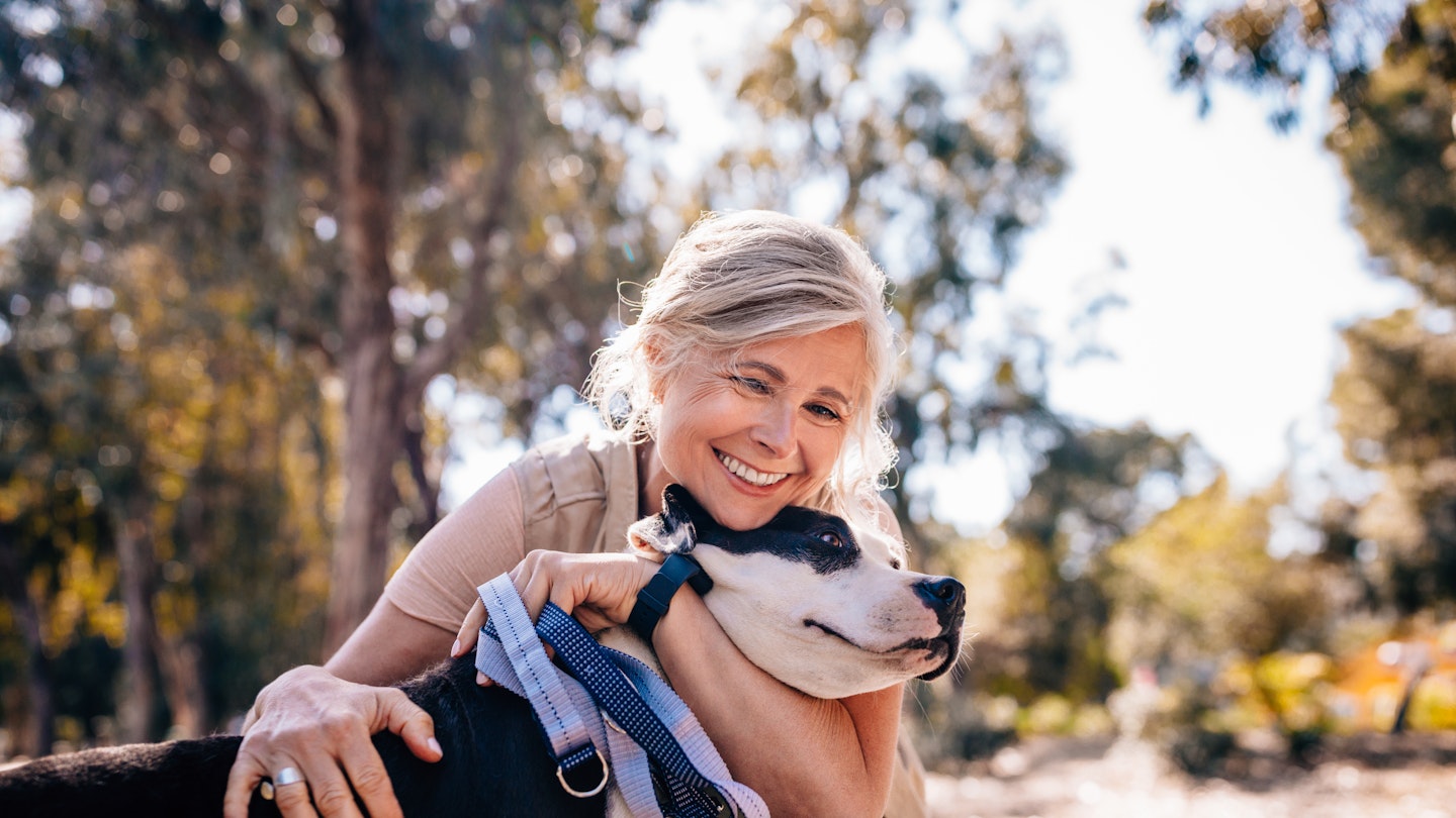 woman hugging dog with lead