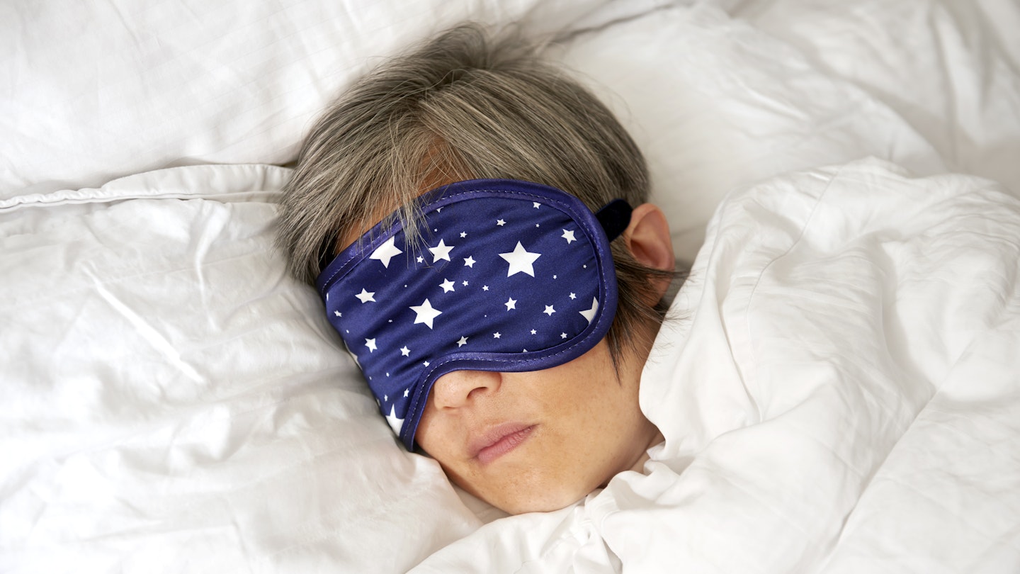 Mature woman sleeping in bed with eye mask