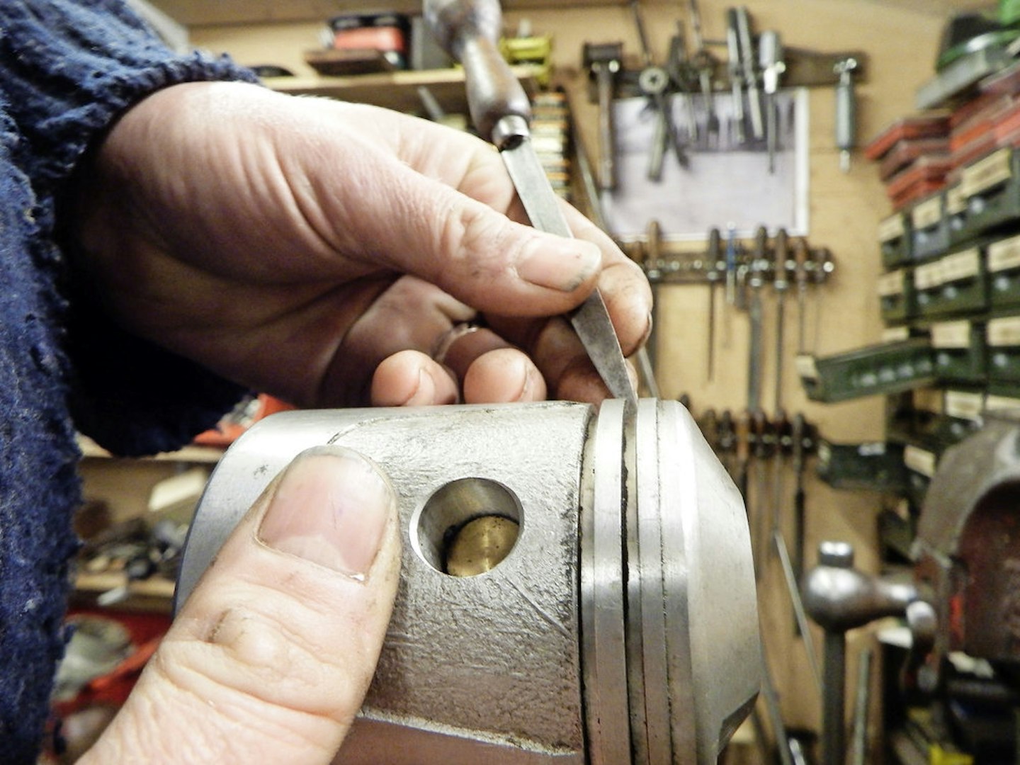 Gently relieving the edge of a piston ring groove removes burrs
