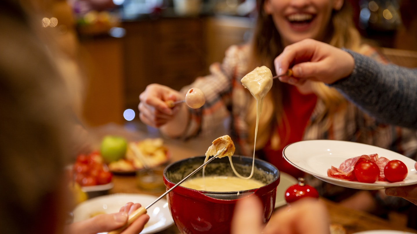 Friends using fondue set