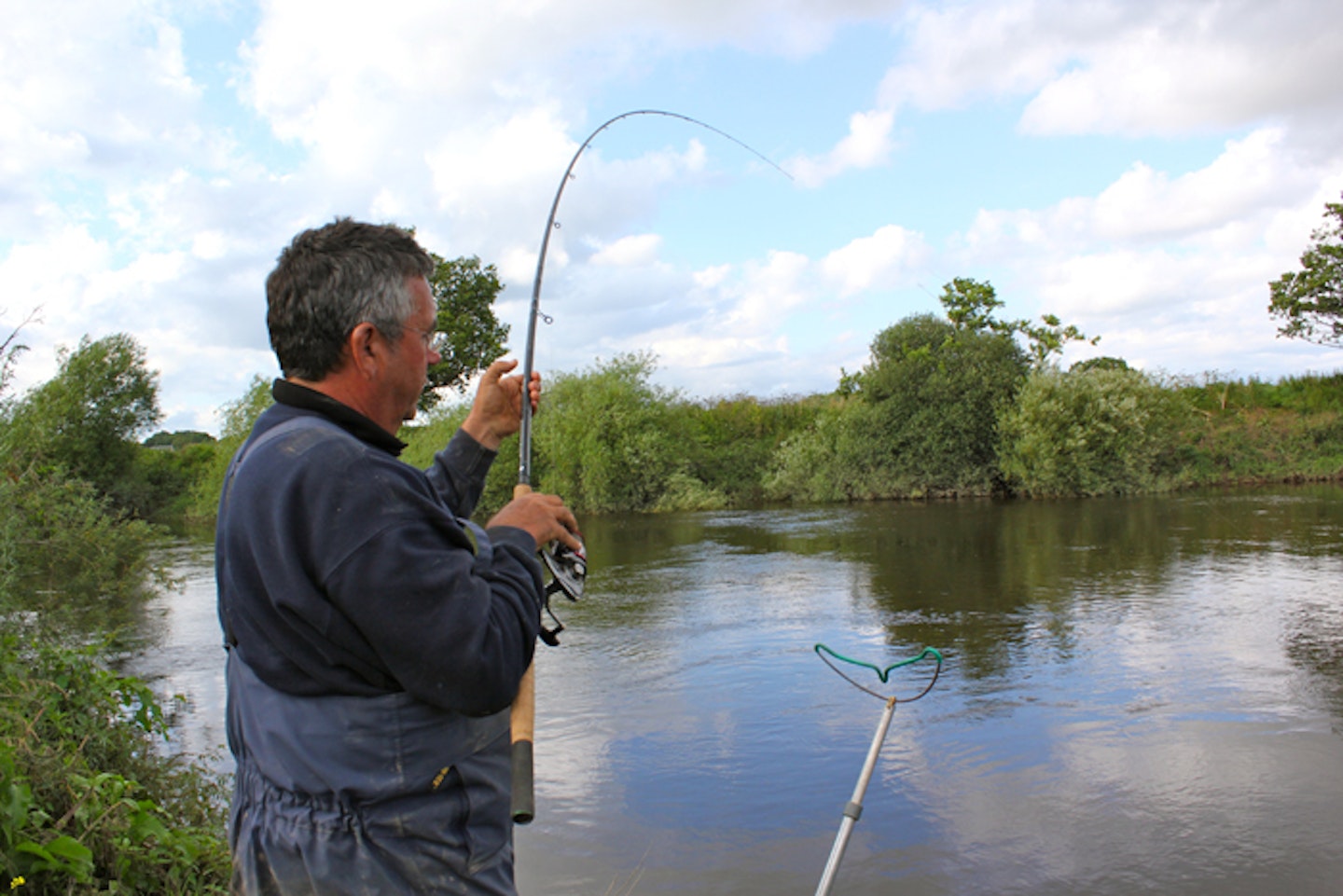 A Couple Fishing Together With A Rod By The Riverside Photo