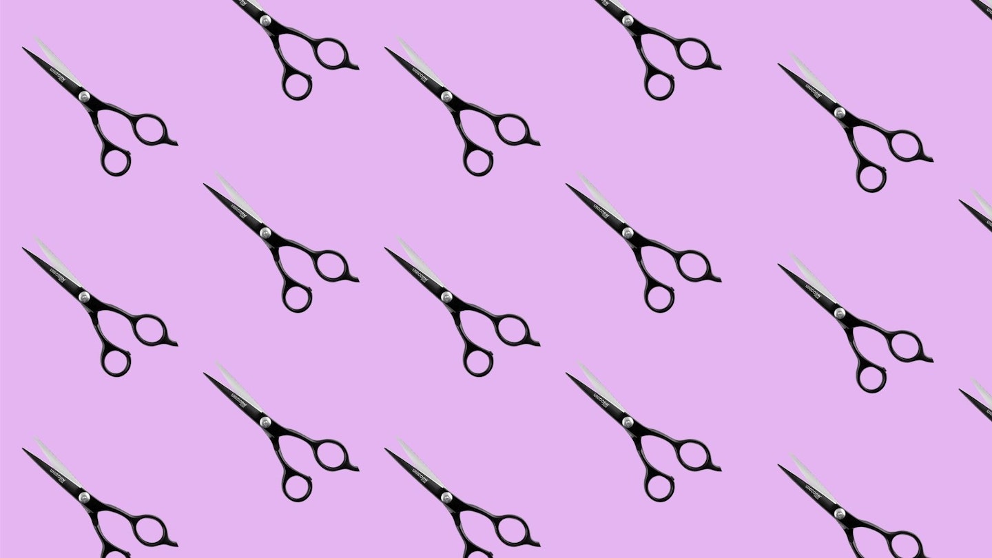 Black hairdressing scissors on a purple block background 