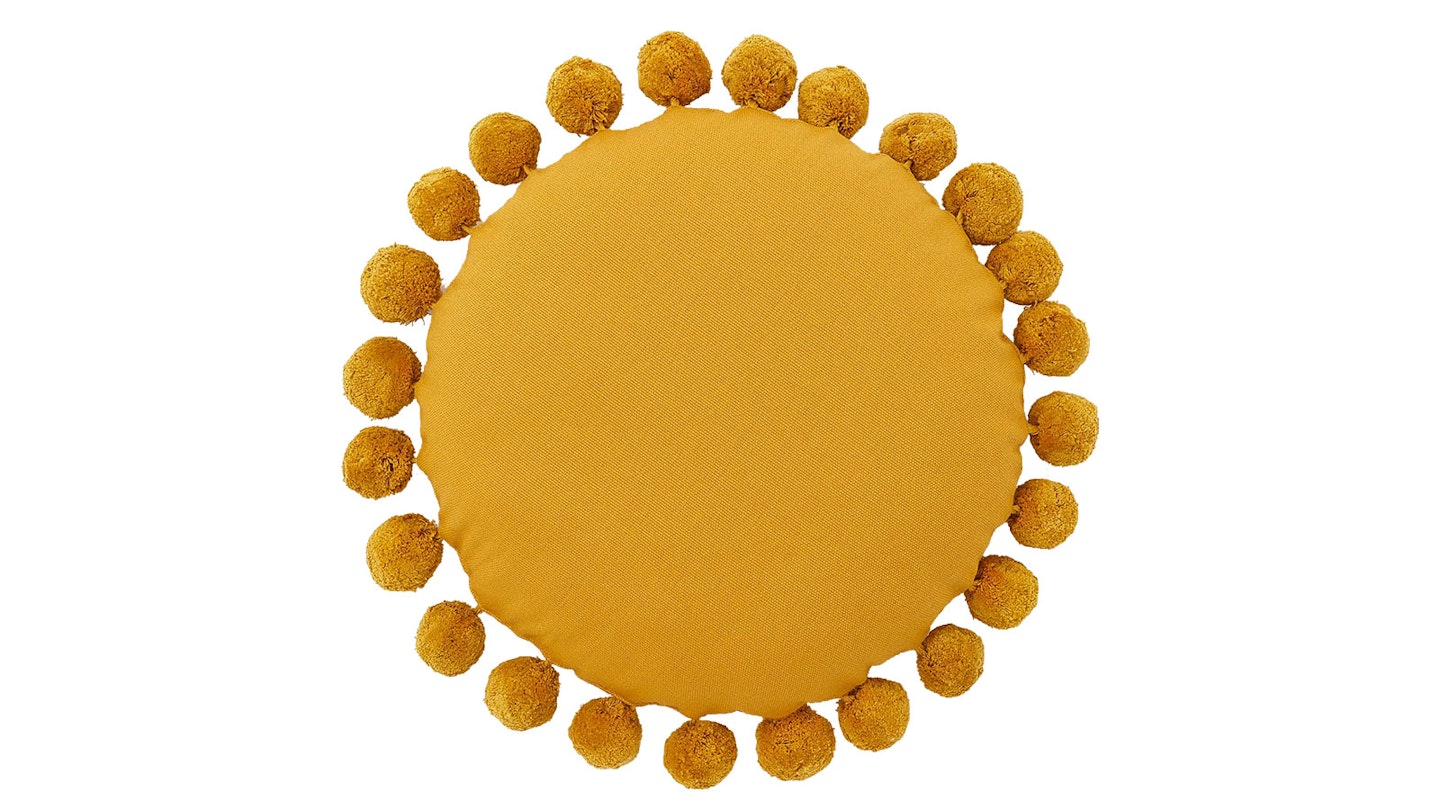 round yellow cushion with pompoms