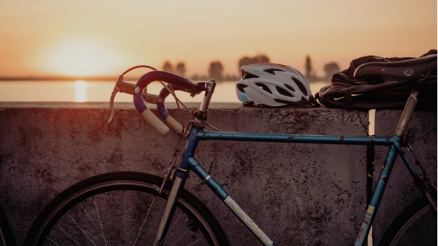 Cycling helmet and bike, sunset behind