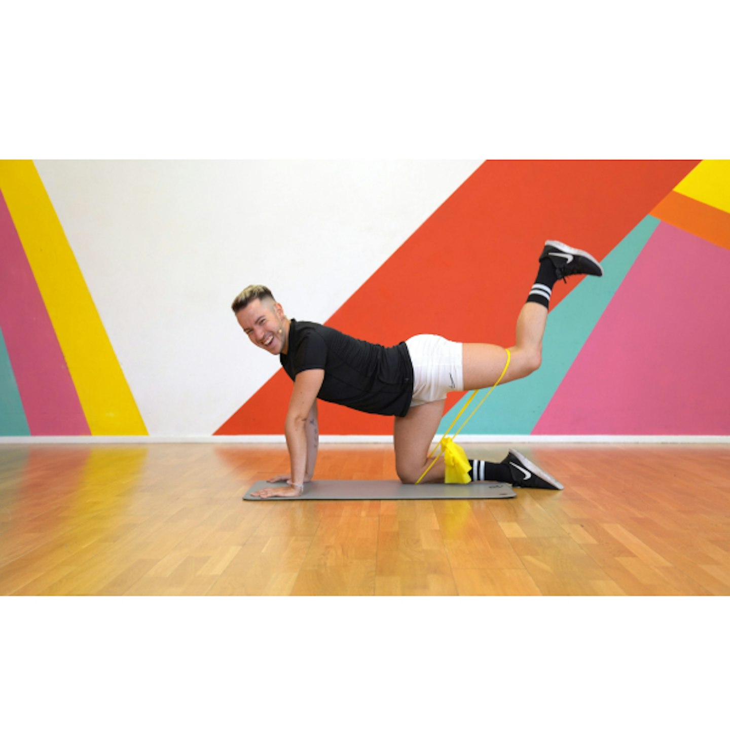 Man working out in front of colourful wall