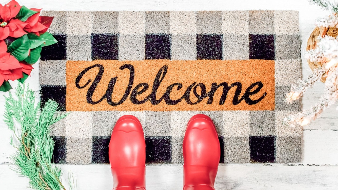 Best door mats: welcome mat with red boots on the front porch
