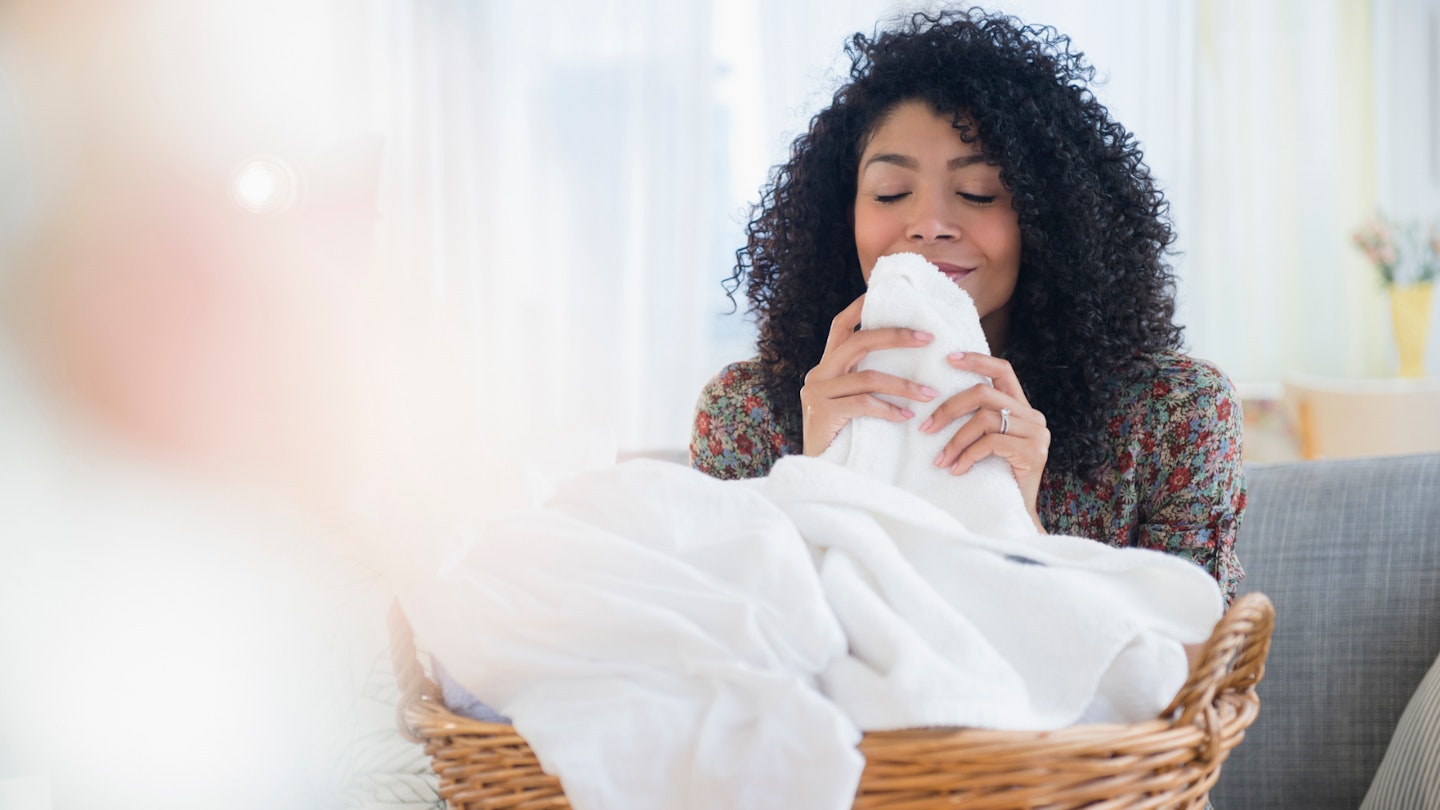 Woman enjoying the smell and feel of a towel