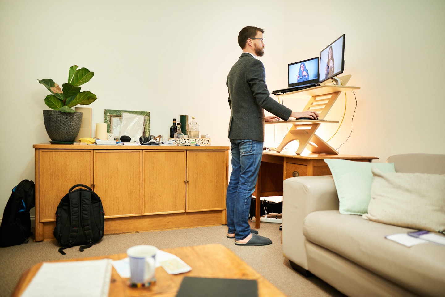 A man using a standing desk converter at home