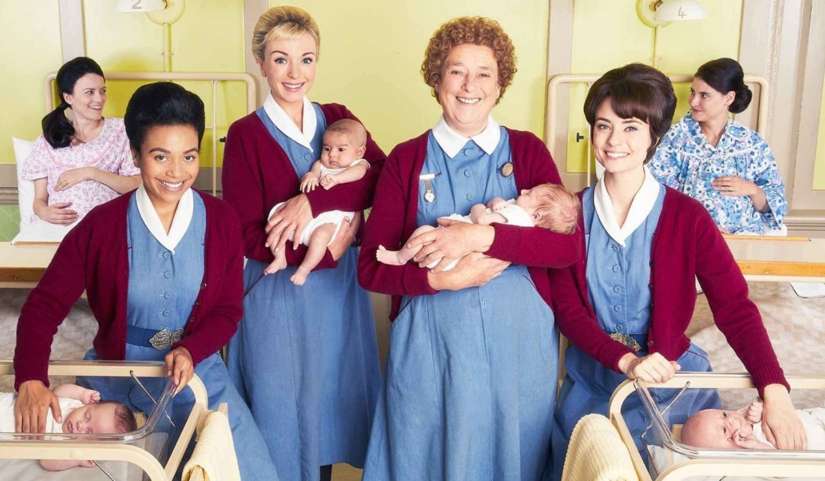 Midwives holding babies and expectant mums in the background