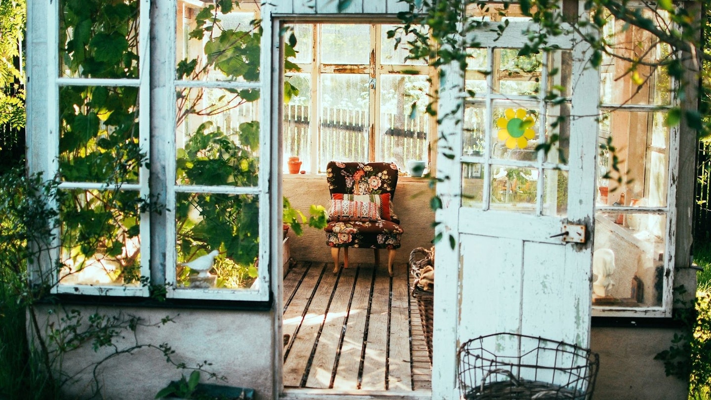 Garden shed with colourful chair and bright interior