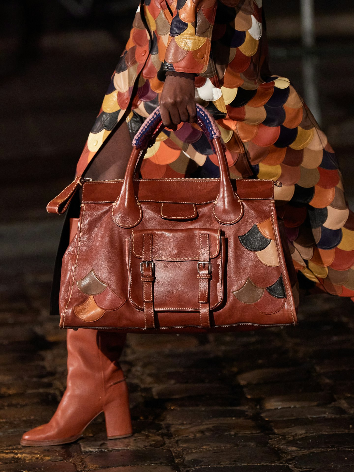 Model carrying a brown leather handbag at Chloé