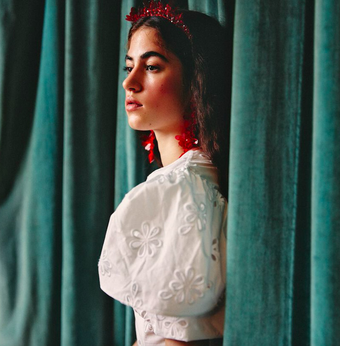 Model wearing a white dress and red hairband from Simone Rocha x H&M