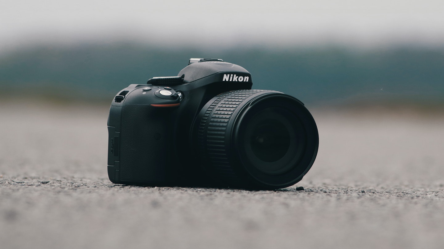 Nikon camera model sitting on a concrete surface 