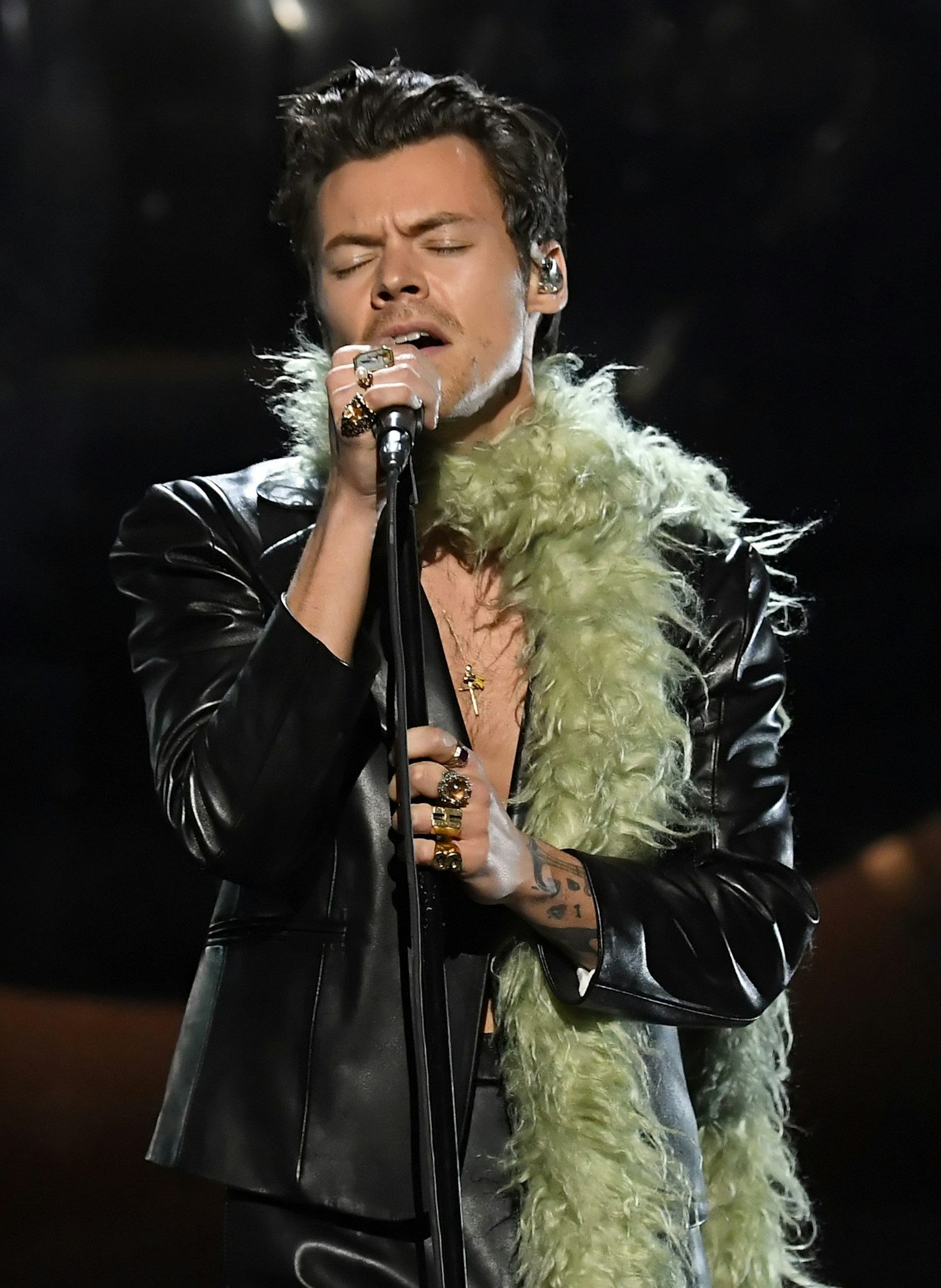 Harry Styles wearing a leather suit and green feather boa at this year's Grammy Awards