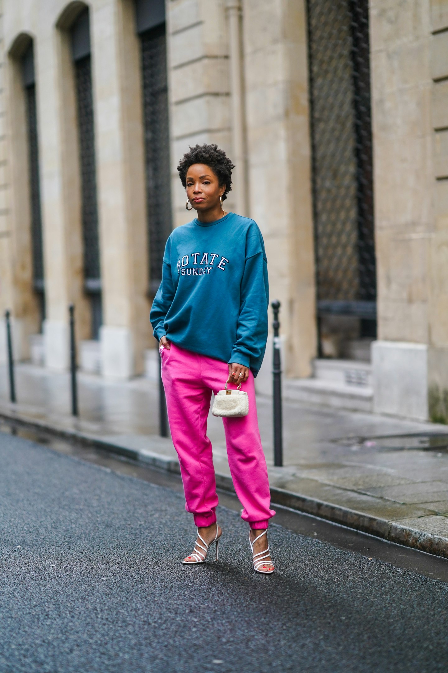 Ellie Delphine wearing bright pink tracksuit bottoms and white heels 