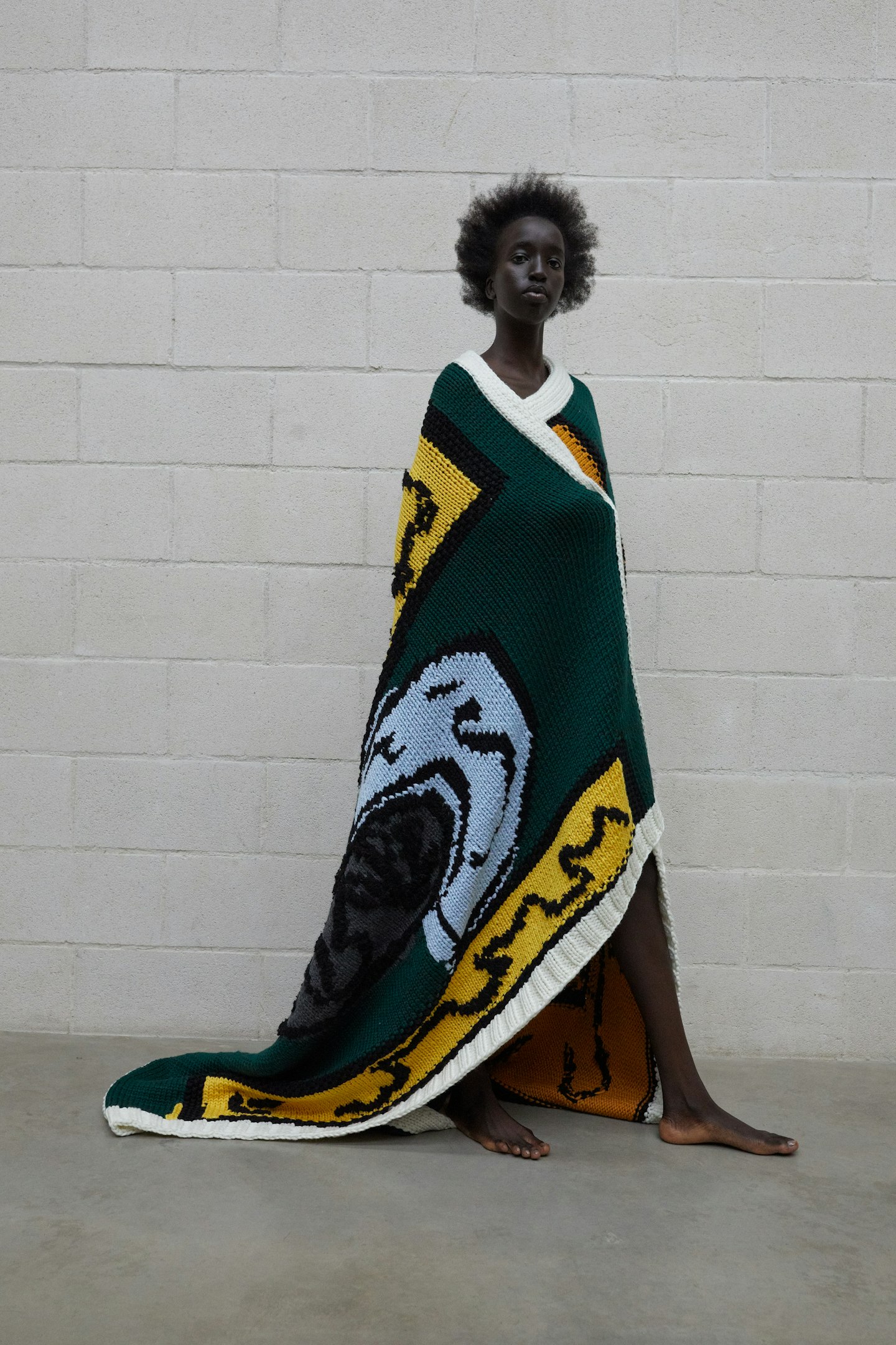 A model wearing a knitted blanket by JW Anderson x Shawanda Corbett