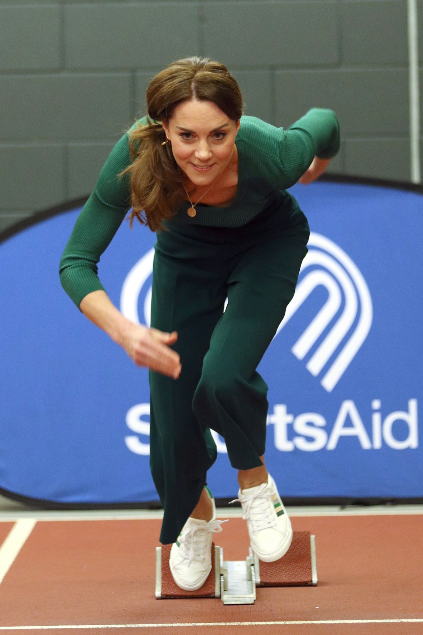 Kate Middleton wearing a green outfit and three-stripe trainers from M&S