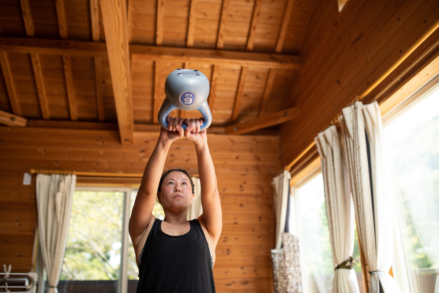 Woman swinging a kettlebell indoors